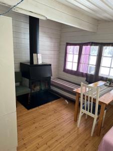 Cette chambre dispose d'une cheminée, d'une table et de chaises. dans l'établissement A cosy cottage in Norrtälje, à Norrtälje
