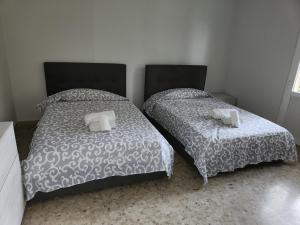 dos camas sentadas una al lado de la otra en un dormitorio en NIKI HOME, en Podenzano