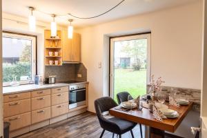een keuken met een houten tafel en stoelen en een eetkamer bij apartHAUS in Haus im Ennstal
