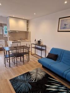 salon z niebieską kanapą i stołem w obiekcie Spacieux et lumineux Appartement w mieście Aulnay-sous-Bois +5 zdjęć