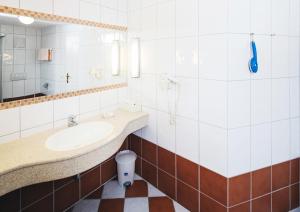 uma casa de banho com um lavatório e um espelho em Pension Schiessling em Anif
