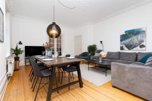 sala de estar con mesa y sofá en Århus bedst placerede lejlighed & udsigt, en Aarhus