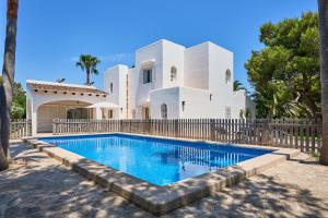 une villa avec une piscine en face d'une maison dans l'établissement Villa Acebuche, à Cala d´Or