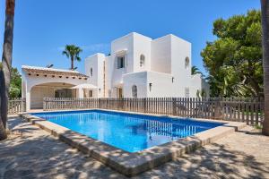 a villa with a swimming pool in front of a house at Villa Acebuche in Cala d´Or