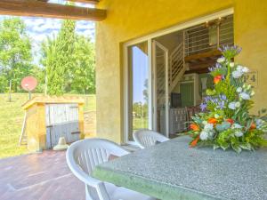 a table with a vase of flowers on a patio at Apartment Il Felciaione-18 by Interhome in Riparbella