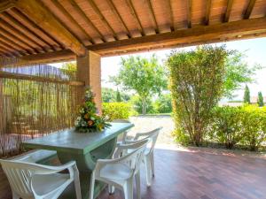 a green table and chairs on a patio at Apartment Il Felciaione-18 by Interhome in Riparbella