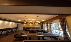 a dining room with tables and chairs and a window at HOTEL CLIFFTON ROYALS in Darjeeling