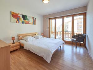 ein Schlafzimmer mit einem großen Bett und einem Balkon in der Unterkunft Apartment Sérandes-4 by Interhome in Les Collons