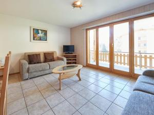 ein Wohnzimmer mit einem Sofa und einem Tisch in der Unterkunft Apartment Sérandes-4 by Interhome in Les Collons