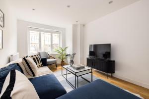 a living room with a couch and a tv at The Walworth Hideout - Elegant 2BDR Flat in London