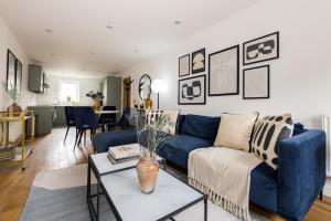 a living room with a blue couch and a table at The Walworth Hideout - Elegant 2BDR Flat in London