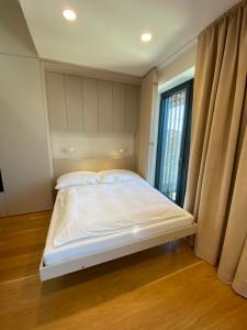 Bett in einem Zimmer mit einem großen Fenster in der Unterkunft Molo Lipno apartmán B232 in Lipno nad Vltavou