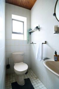 een witte badkamer met een toilet en een wastafel bij Ocean Wave No.1 Self Catering in Swakopmund +19 foto's