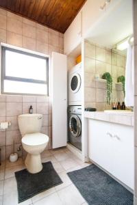 een badkamer met toilet en wasmachine bij Ocean Wave No.1 Self Catering in Swakopmund