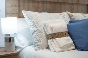 ein weißes Bett mit Kissen und Handtüchern darauf in der Unterkunft Casa Piñera Cudillero 
