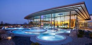 a large building with three pools in front of it at Au Petit Bonheur in Thannenkirch