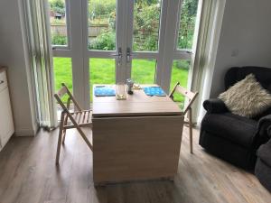 a living room with a desk with chairs and a couch at The Annex - Modern Studio Flat in Mold