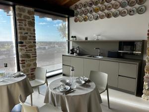 una cocina con 2 mesas y sillas y una cocina con ventanas en Nuovo B&B Colline San Benedetto, en Marostica