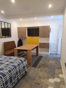 Cette chambre dispose d'une table, d'un canapé et d'une cuisine. dans l'établissement Beau studio moderne proche de CDG/Paris/Parc d'Expo, à Aulnay-sous-Bois