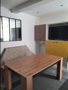 un salon avec une table en bois et un canapé dans l'établissement Beau studio moderne proche de CDG/Paris/Parc d'Expo, à Aulnay-sous-Bois