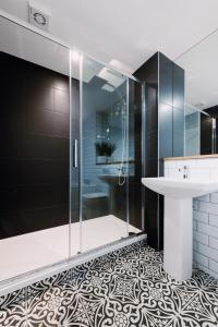 a bathroom with a glass shower and a sink at SmartSleep Apartments in Glasgow