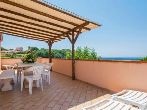 un patio con mesa y sillas en la azotea en Apartment Il Felciaione by Interhome, en Riparbella