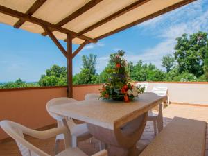 una mesa y sillas en un patio con techo en Apartment Il Felciaione by Interhome, en Riparbella