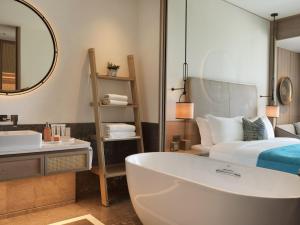 a bathroom with a tub and a bed and a mirror at City of Dreams Mediterranean - Integrated Resort, Casino & Entertainment in Limassol