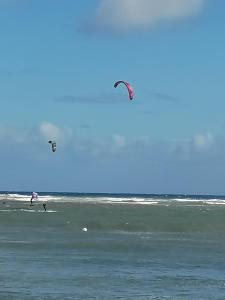 Due persone sulla spiaggia volano aquiloni nell'oceano di Casa Naturaleza 2 a Caleta De Fuste