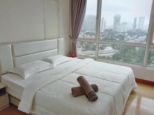 een slaapkamer met een wit bed en een groot raam bij Habibi HoMe KLCC in Kuala Lumpur