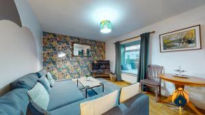 a living room with a blue couch and a table at *Cosy Annexe in Forest of Dean* in Coleford