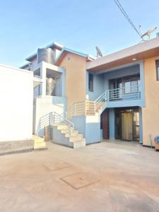 une maison avec des escaliers dans un parking dans l'établissement Freedom Homes Kigali, à Kigali