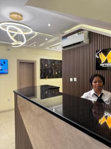 a man sitting at a counter in a lobby at MITOS LUXURY SUITES (BODE THOMAS) in Lagos