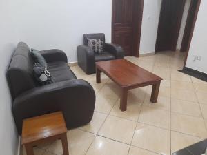 Freedom Homes Kigali في كيغالي: غرفة معيشة مع كرسيين وطاولة