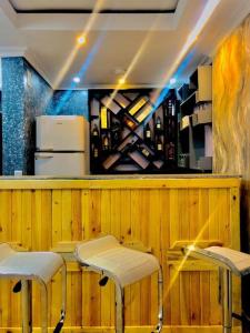 a bar with two stools in front of a counter at Freedom Homes Kigali in Kigali
