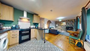 a kitchen with green walls and wooden cabinets at *Cosy Annexe in Forest of Dean* in Coleford