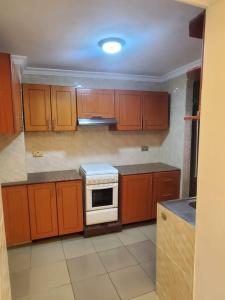 a kitchen with wooden cabinets and a stove at Freedom Homes Kigali in Kigali