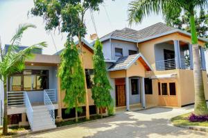 a house with palm trees in front of it at Freedom Homes Kigali in Kigali