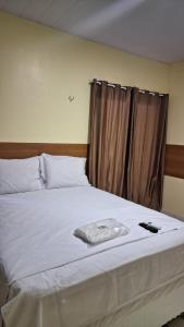 a bedroom with a bed with a brown curtain at Saymon Hotel in Portel