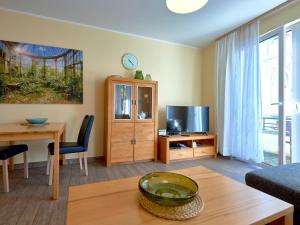 a living room with a table and a tv at Villa Annika - Apt. 08 in Ostseebad Sellin