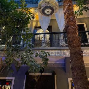 a building with a staircase and a balcony with a tree at Riad des Mile Nuits in Marrakesh