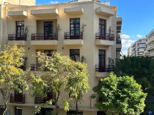 budynek z balkonami i drzewami przed nim w obiekcie The Maroon Bottle Luxury Suites w Salonikach