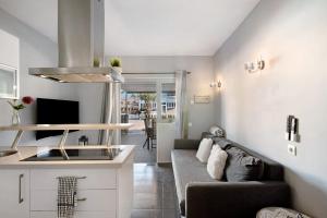 Una sala de estar con un sofá y una cocina. en Place Oasis Green Luxury Pool, en Maspalomas