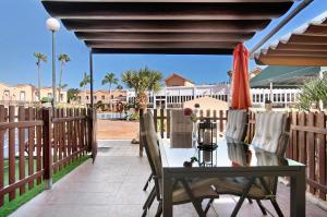 Un patio con una mesa y sillas y una sombrilla. en Place Oasis Green Luxury Pool, en Maspalomas