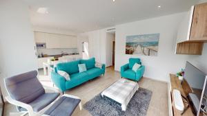 a living room with a blue couch and two chairs at Punto Residences "Villa Deluxe" in Los Alcázares