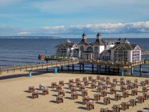 a pier with chairs on the beach next to the water at Villa Annika - Apt. 08 in Ostseebad Sellin