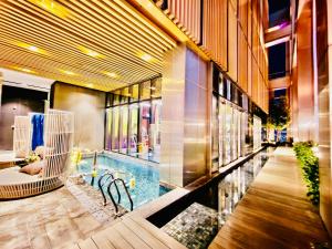 um lobby com uma piscina no meio de um edifício em Tropicana Residence Klcc @ Roof Top Swimming Pool em Kuala Lumpur