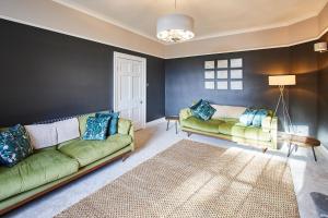 una sala de estar con 2 sofás verdes y una alfombra en Host & Stay - South View, en High Newton