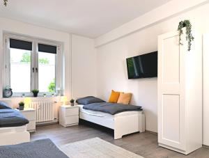 ein Schlafzimmer mit einem Bett und einem TV an der Wand in der Unterkunft Monteurwohnung mit Balkon in Hattingen