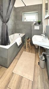 ein Badezimmer mit einer Badewanne und einem Waschbecken in der Unterkunft Monteurwohnung mit Balkon in Hattingen